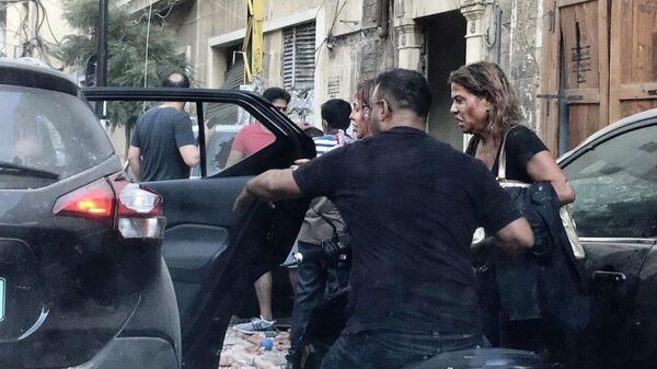 Люди, пострадавшие от осколков витрин, выбитых в результате взрыва в районе порта в Бейруте