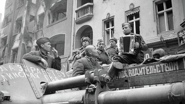 Советские солдаты слушают баян на улицах Берлина