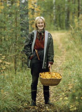 A mushroom picker properly dressed for autumn in the forest.