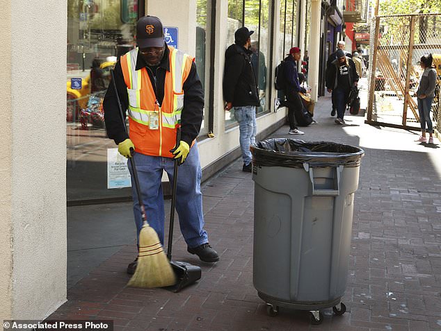 A city sanitation worker clears away rubbish on Market Street in San Francisco on April 26