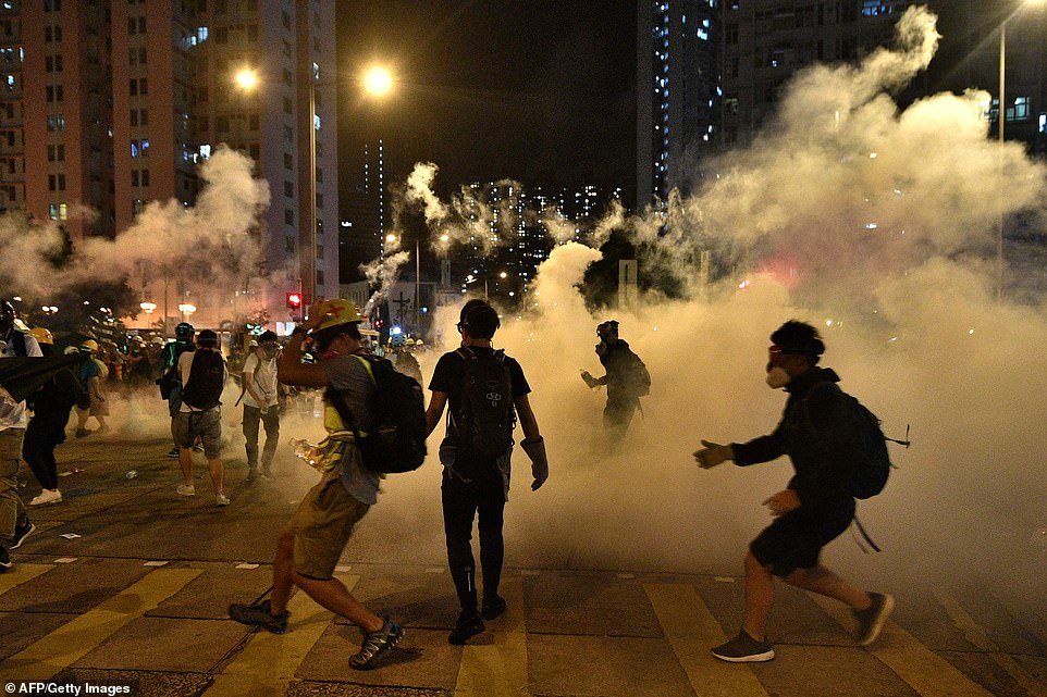 Last night police fired tear gas, pictured outside of a police station in the Wong Tai Sin district of Hong Kong, at protesters