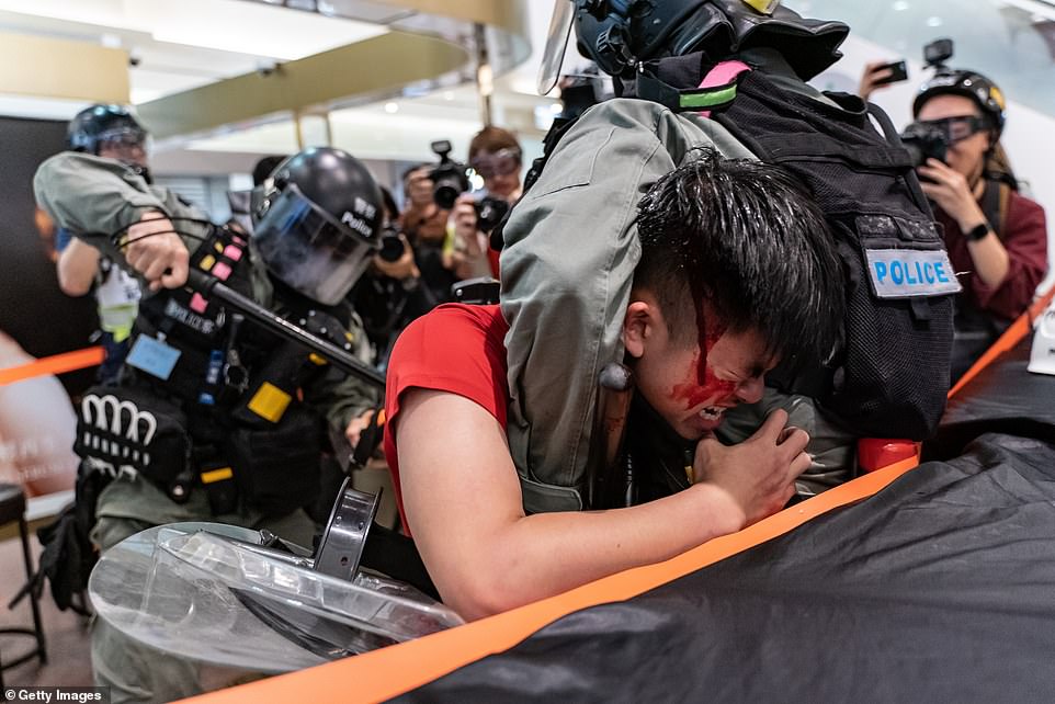 A man is detained by riot police during a demonstration in a shopping mall at Sheung Shui district today