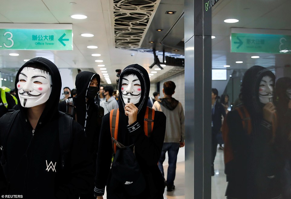 Anti government protesters wearing Guy Fawkes masks march inside the Sheung Shui shopping mall in Hong Kong, China today