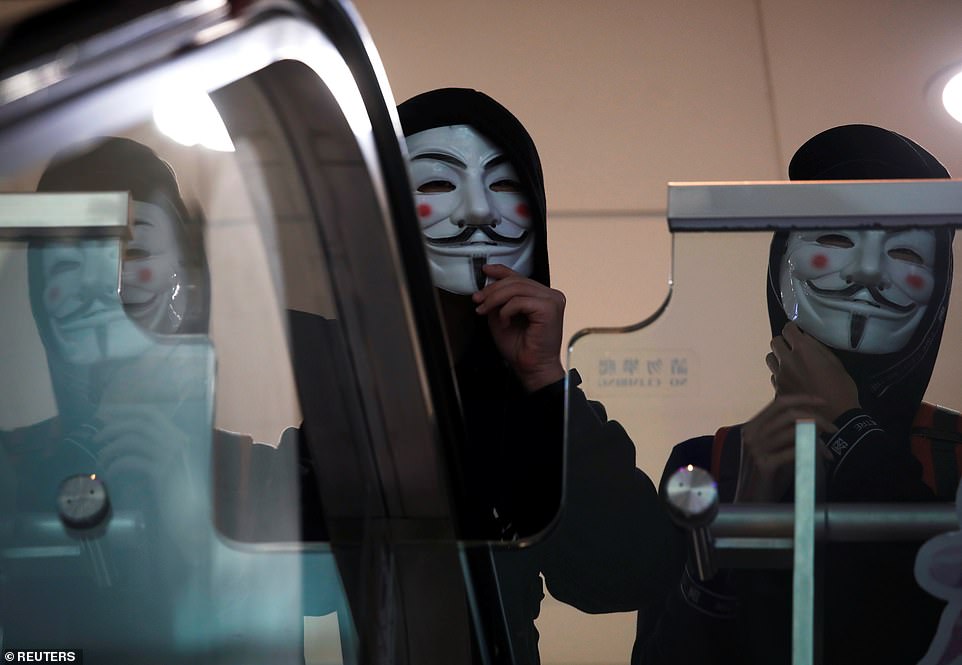 Anti government protesters wearing Guy Fawkes masks march inside the Sheung Shui shopping mall in Hong Kong today