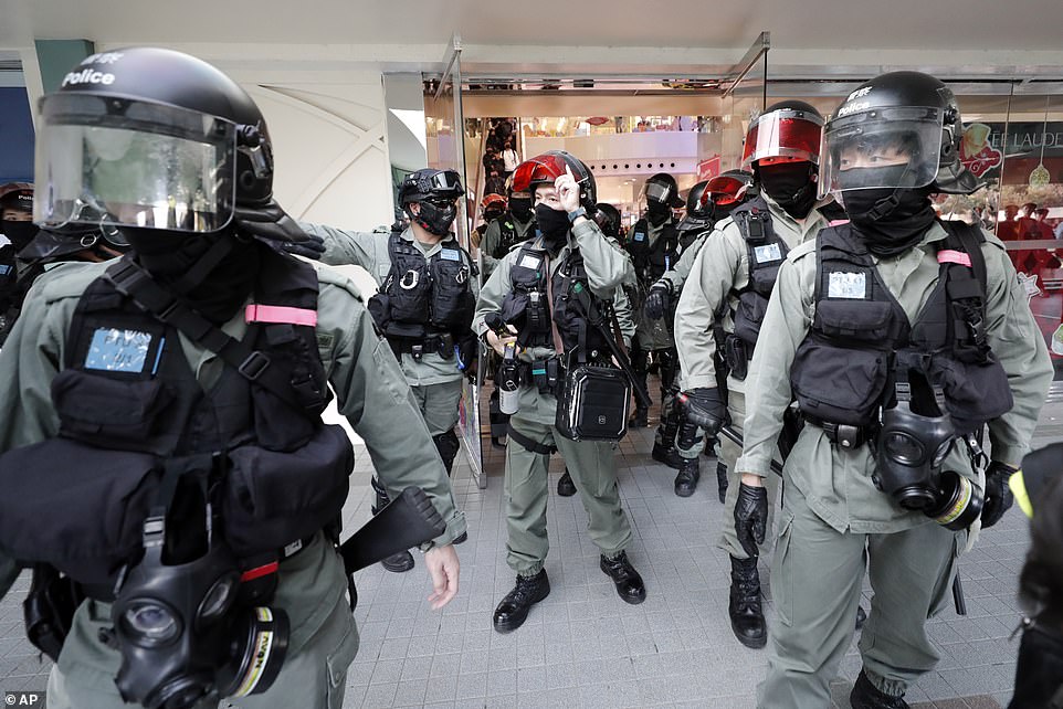 Officers equipped with riot helmets, pepper spray and gas masks are pictured today at the Sheung Shui mall in Hong Kong