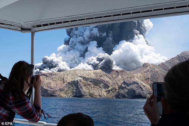 Pictured: Tourists capture photos of the White Island (Whakaari) volcano eruption in the Bay of Plenty, New Zealand on 09 December 2019