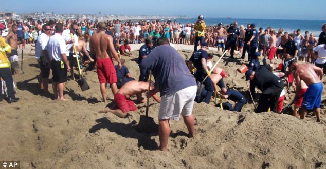 Digging deep: The community of sunbathers came together to drag the boy out
