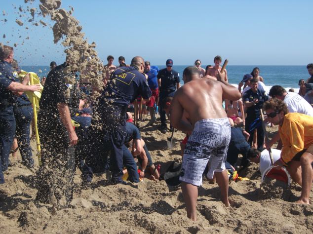 People dig frantically to pull Matt Mina from the sand