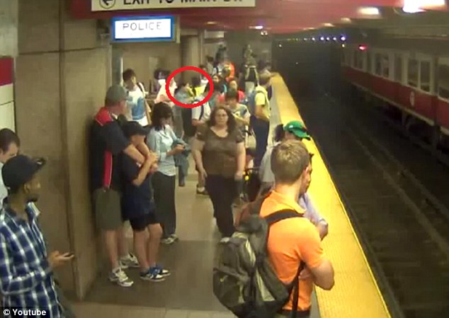 Eyes forward: The woman walks quickly across the crowded platform in the CCTV footage, looking straight ahead of her