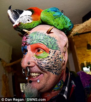 Ted Richards, who had his ears cut off to look like his parrots, with his pet Harlequin Macaw Teaka
