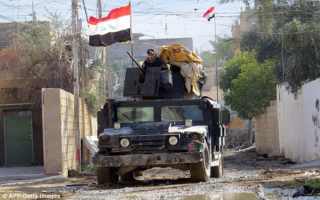 Fight back: Pictured, Iraqi pro-government forces drive a military vehicle during battles with ISIS in Ramadi