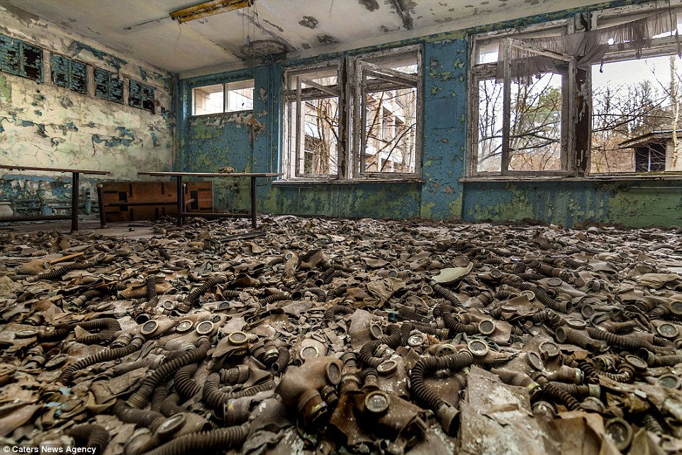 Eerie: A sea of gas masks is left behind in an abandoned building as the walls and roof rot and crumble in the wake of the 1986 Chernobyl disaster, the world