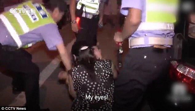 Collapse: The woman fell to the ground before she was helped to her feet by officers
