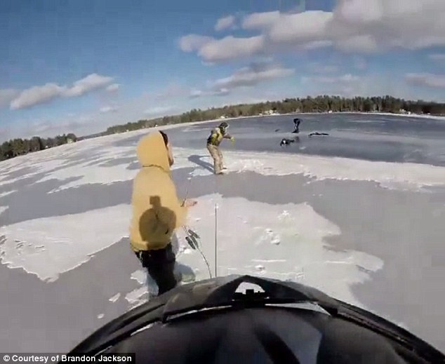 Hanging on tight: The fishermen are seen pulling the teen out of the frigid waters using mountain climber rope as she makes it back on the ice