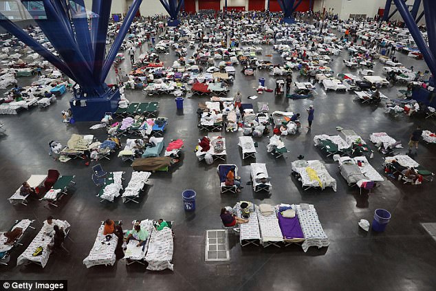 People take shelter at the George R. Brown Convention Center after flood waters from Hurricane Harvey inundated Houston, Texas on August 29, 2017. At the time, the evacuation center has already received more than 9,000 evacuees with more arriving