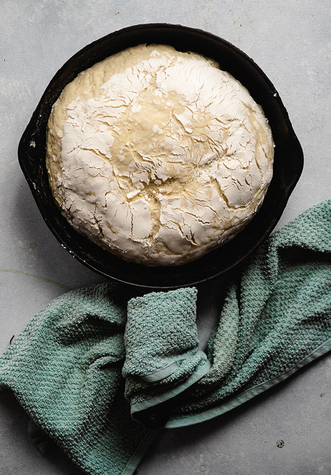 overhead photo of bread dough in a cast iron skillet