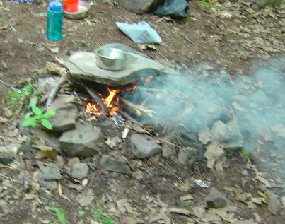 campfire cooking on top of rock