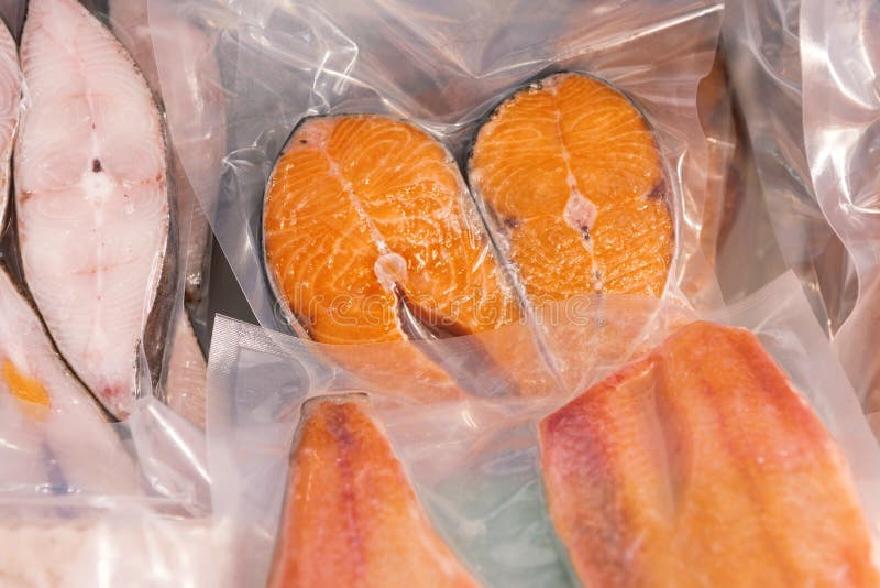 Frozen steaks of red fish. Fish packed vacuum bags. royalty free stock images