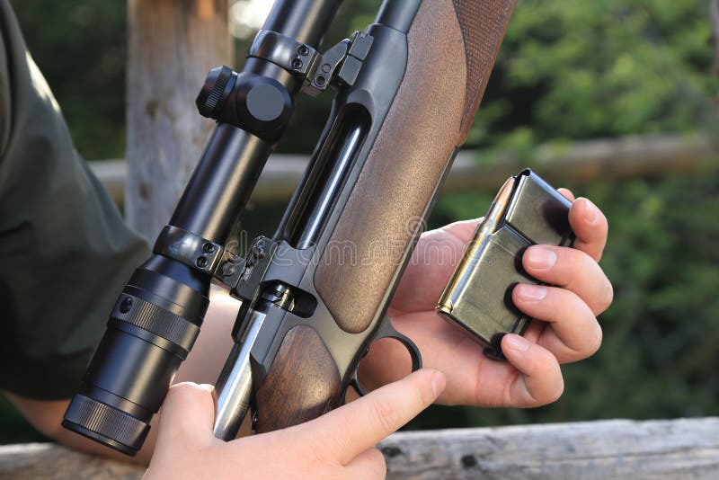 Hunter loading his hunting rifle gun with magazine stock photography