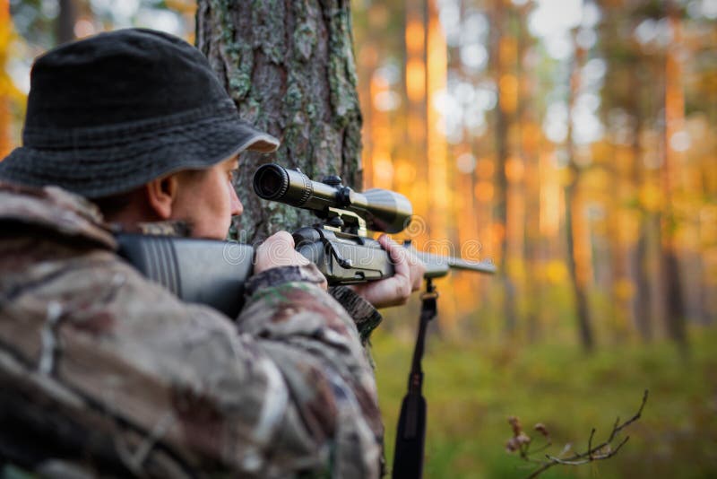 Hunter looking into rifle scope stock photo