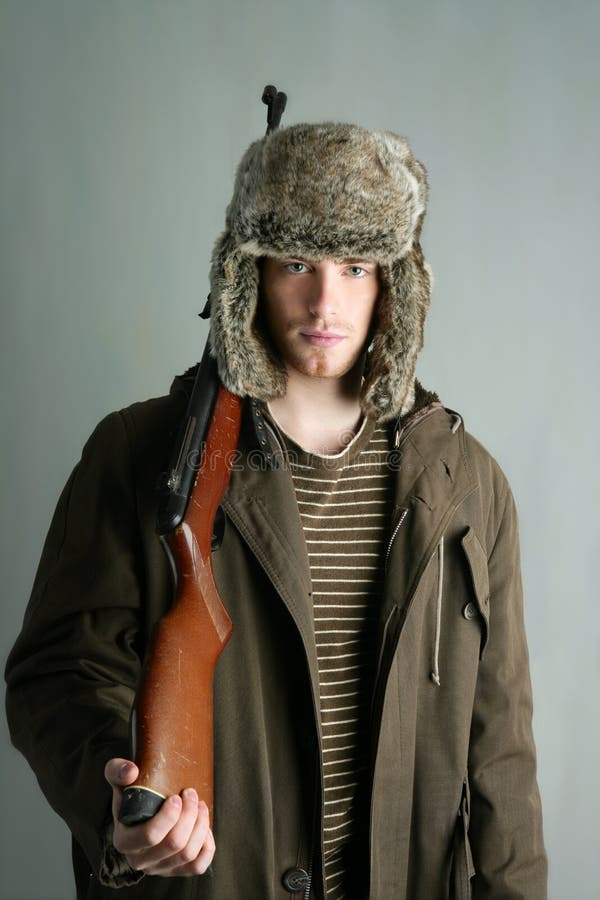 Hunter man fur winter hat holding rifle gun stock photo