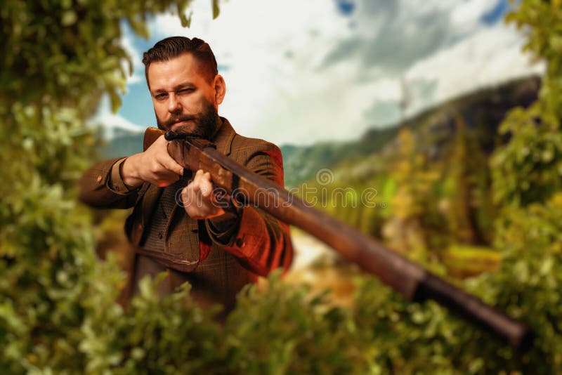 Hunter sitting in the bushes and aiming a rifle. royalty free stock photos