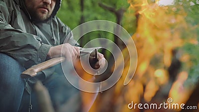Slow Motion Of Casual Strong Man Works with Ax and Wood near Warm Bonfire in Camp in Wild Deciduous Forest. stock video