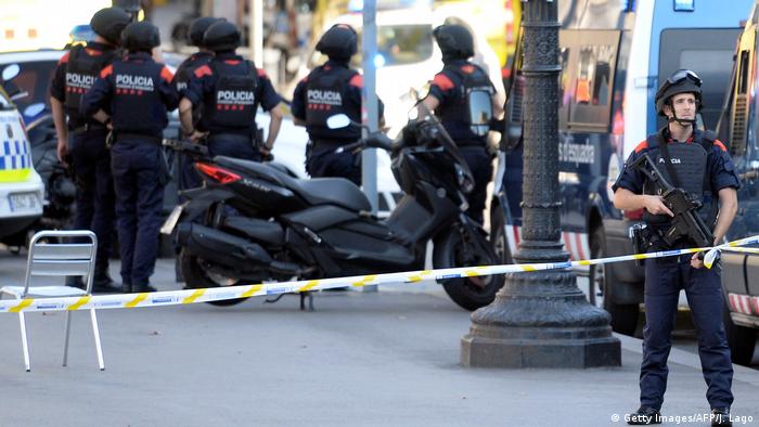 Armed policemen stand in a cordoned off area