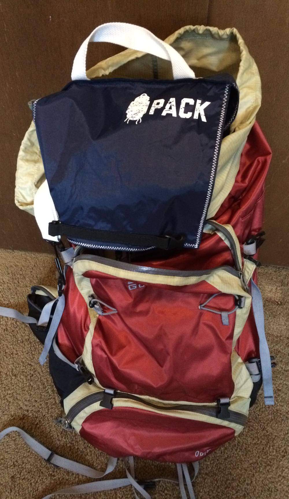 Packing a backpack might require internal organizers, like this navy blue one sitting on an orange and yellow backpack